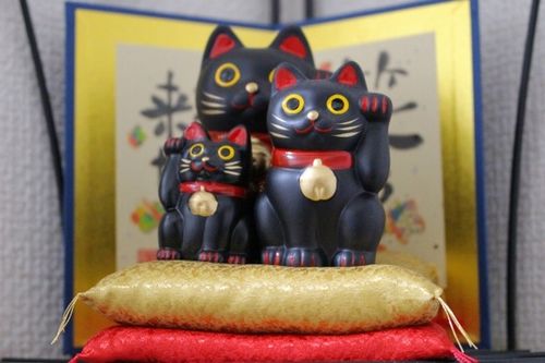 笠森観音の境内に置かれた縁起物の招き猫と祈願に訪れる参拝客の様子