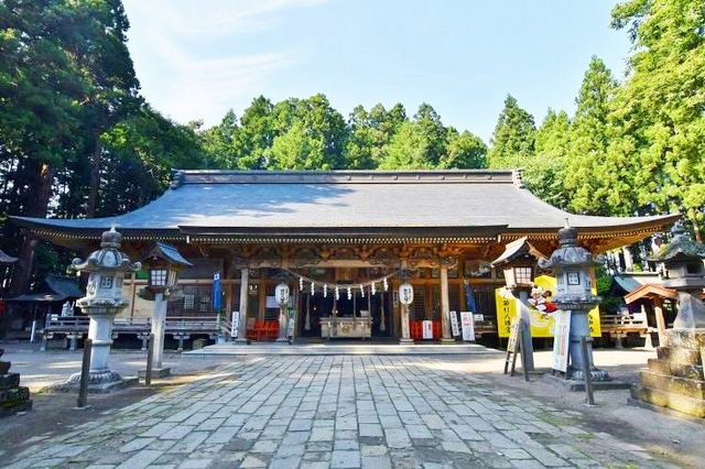 櫛引八幡宮の立派な鳥居から続く石畳の参道と周囲の木々