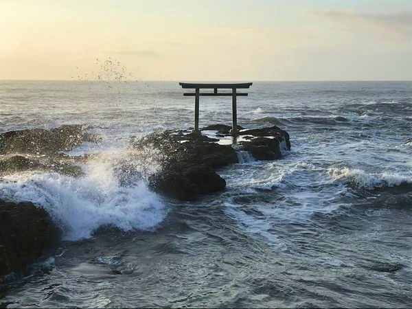 荒波に打ち寄せる海の中に立つ大洗磯前神社の神磯の鳥居