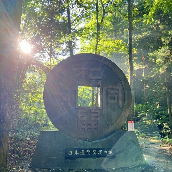 和同開珎のモニュメントが置かれた金運パワースポット聖神社の境内